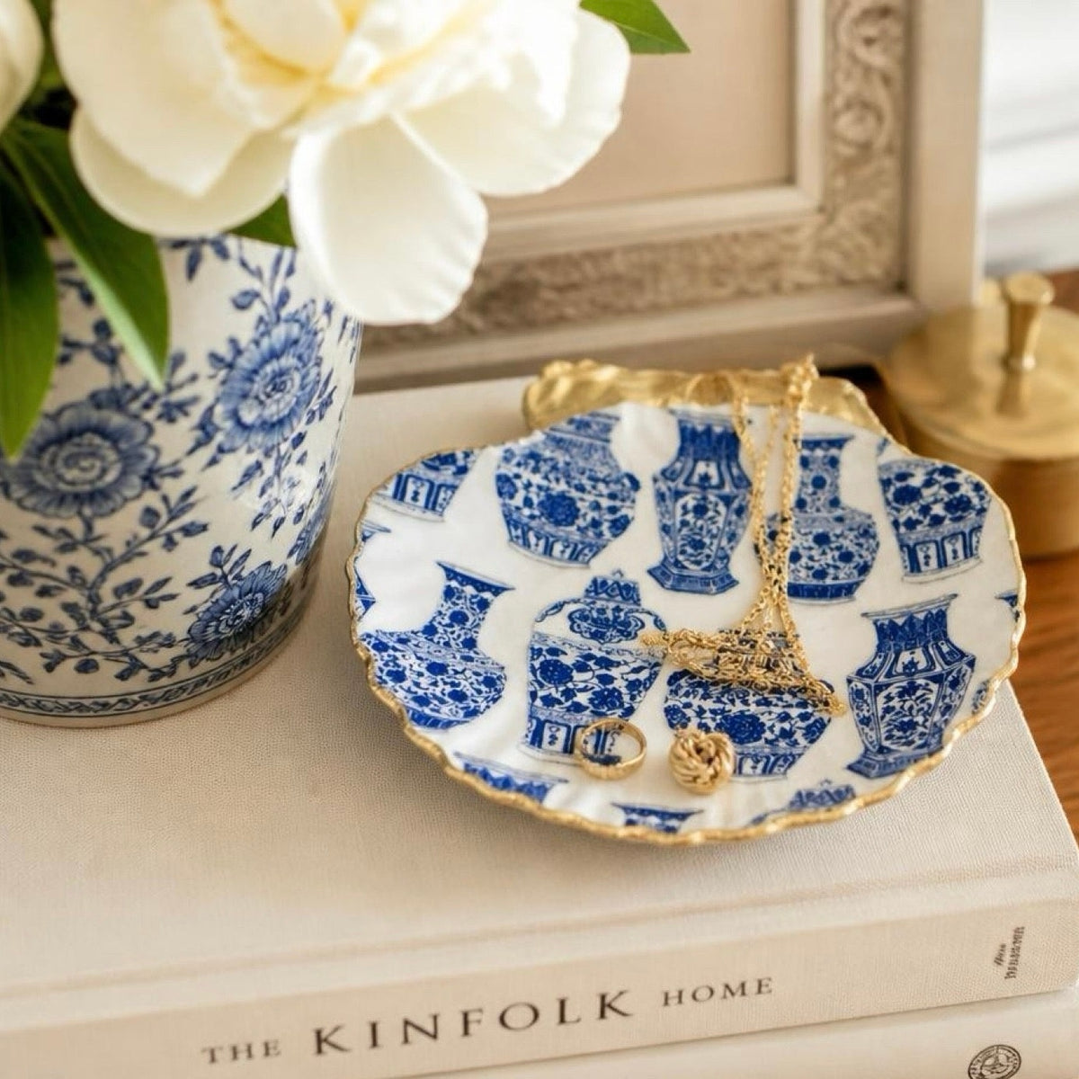 A decorative jewelry dish with a blue and white ginger jar pattern and gold trim